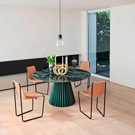 Ambiente de mesa redonda Plissé en color verde con sillas Apelle en cuero