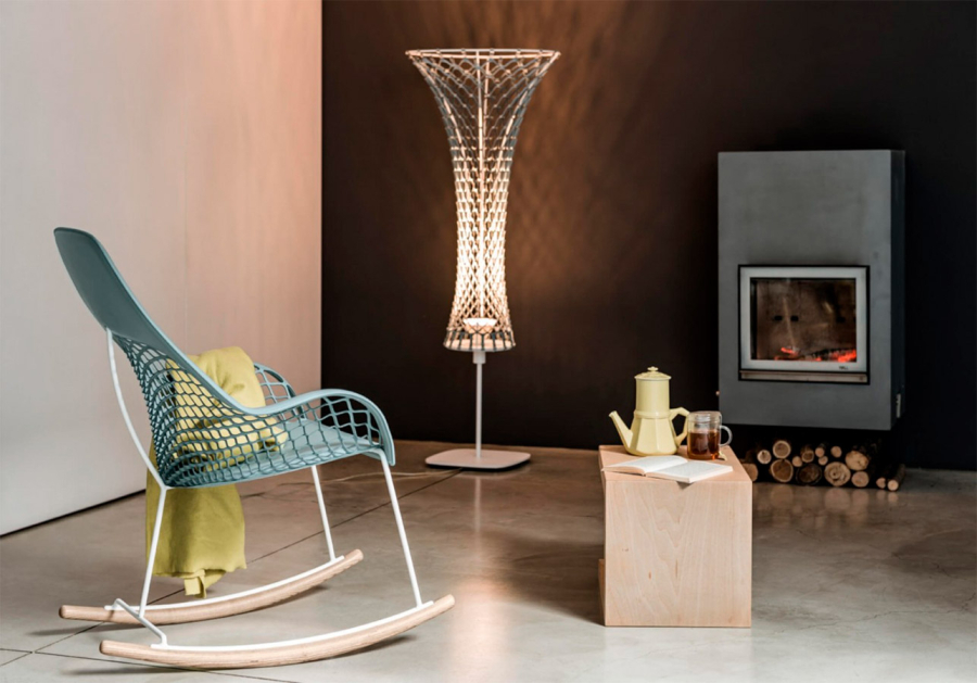 Ambiente acogedor de salón con chimenea y mecedora Guapa tapizada en cuero azul claro