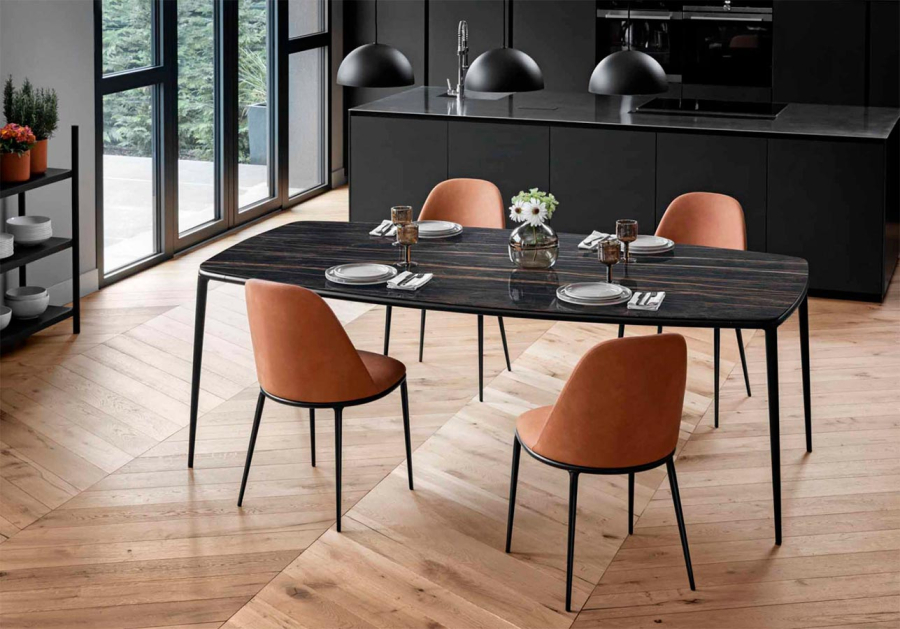 Ambiente de comedor con cuatro sillas Lea tapizadas en cuero toscano