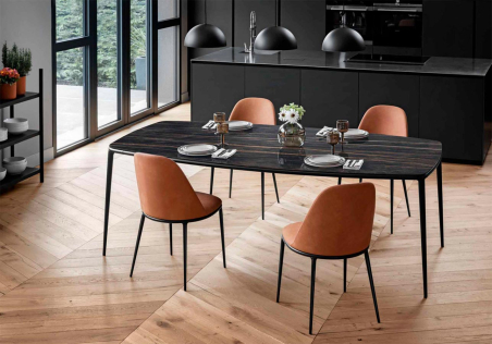 Ambiente de comedor con cuatro sillas Lea tapizadas en cuero toscano