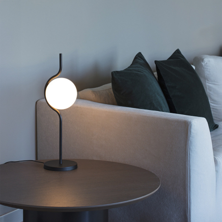 Lámpara de mesa Levita de Faro Barcelona, acabada en negro mate, sobre mesa en ambiente de salón