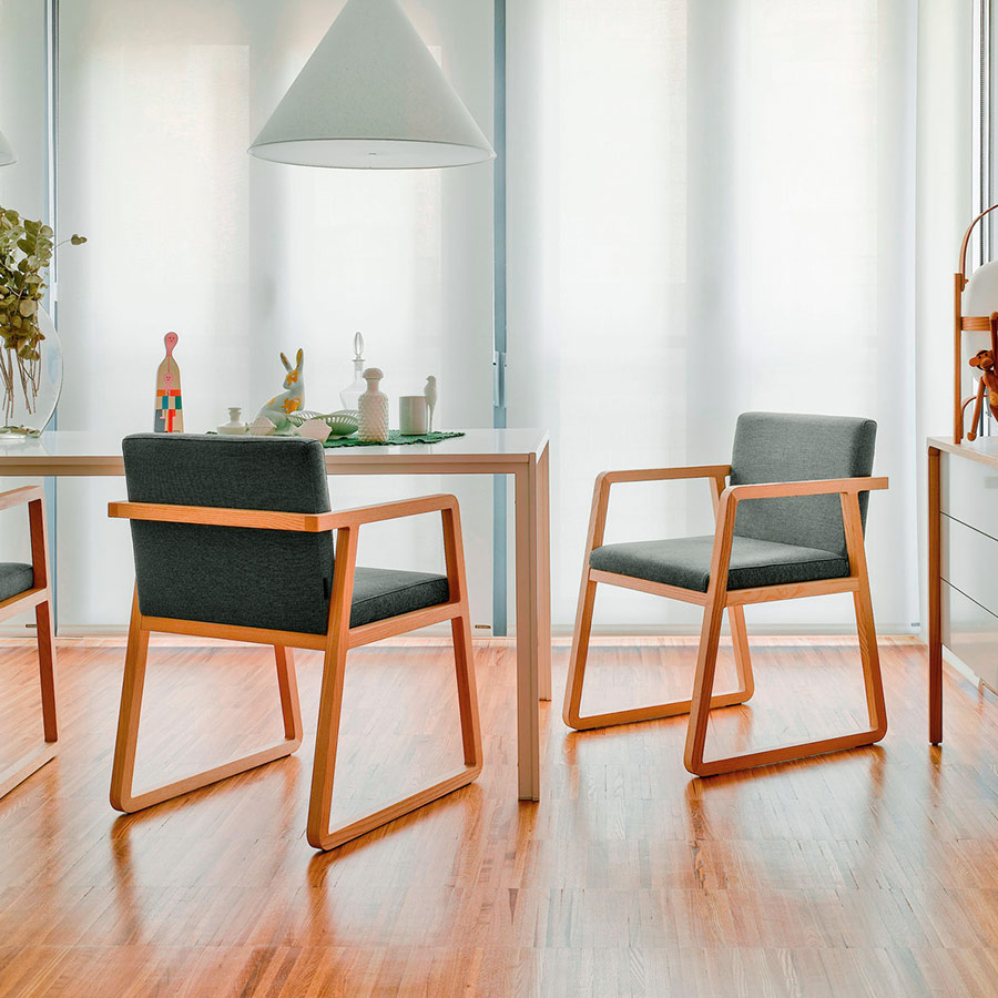 Ambiente de comedor con sillas Midori de Sancal tapizadas en color gris oscuro con estructura de madera