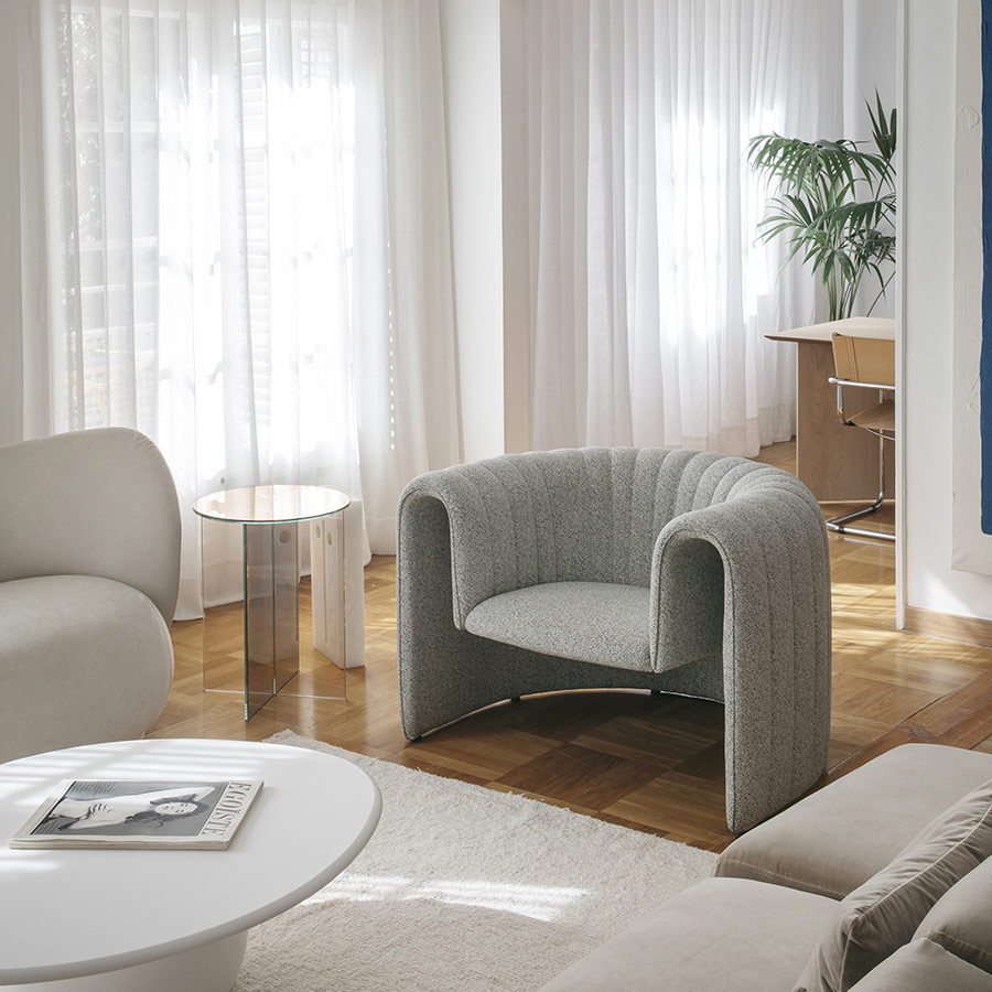 Ambiente de salón con sillón Remnant tapizada en tela gris clarita