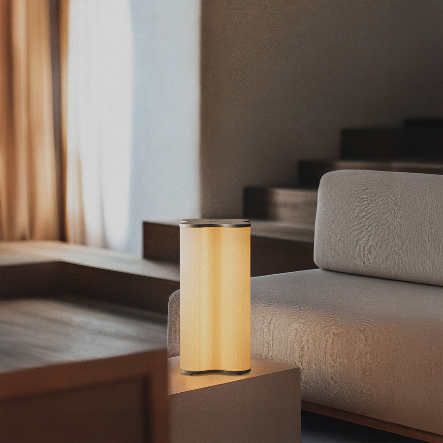 Lámpara de mesa Equis con tapas en acabado arena, en ambiente.