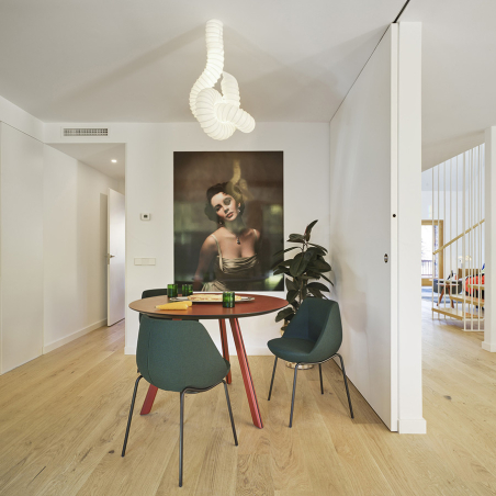 Ambiente de comedor particular con sillas Magnum de Sancal, con patas metálicas negras y asiento tapizado en verde