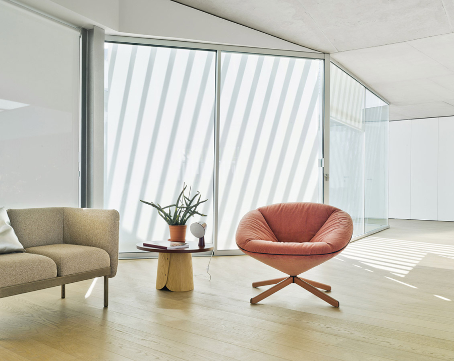 Ambiente con butaca Tortuga de Sancal, con base de madera natural y tapizado en color rosa