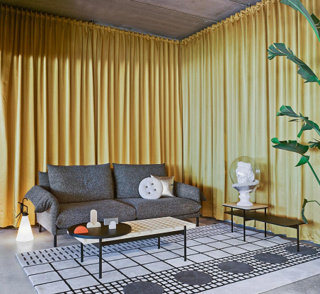Ambiente con sofá Alpino de la firma Sancal, tapizado en tela color gris oscuro con patas en color negro