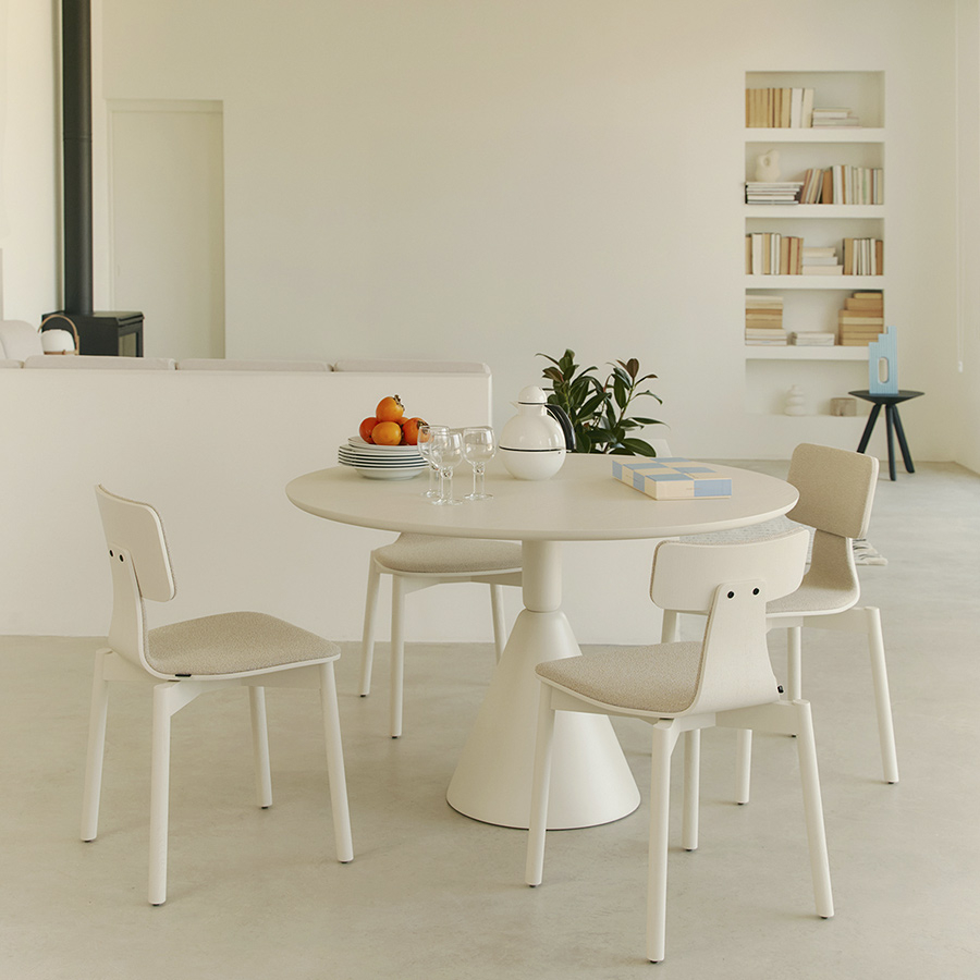 Ambiente de comedor con sillas 40 de Sancal, con patas y tapizado en color blanco