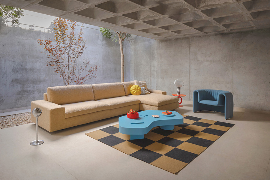 Ambiente de salón con sofá chaiselongue Air de Sancal, tapizado en tela color beige