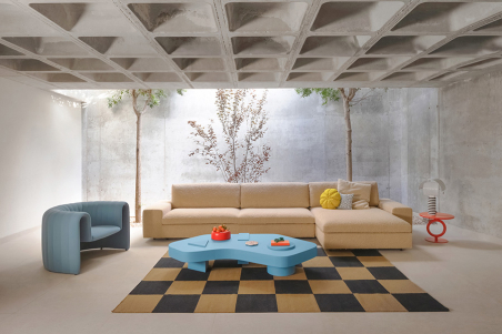 Vista frontal en ambiente de salón del modelo Air con chaiselongue, acompañado de una mesa de centro y un sillón en tonos azules