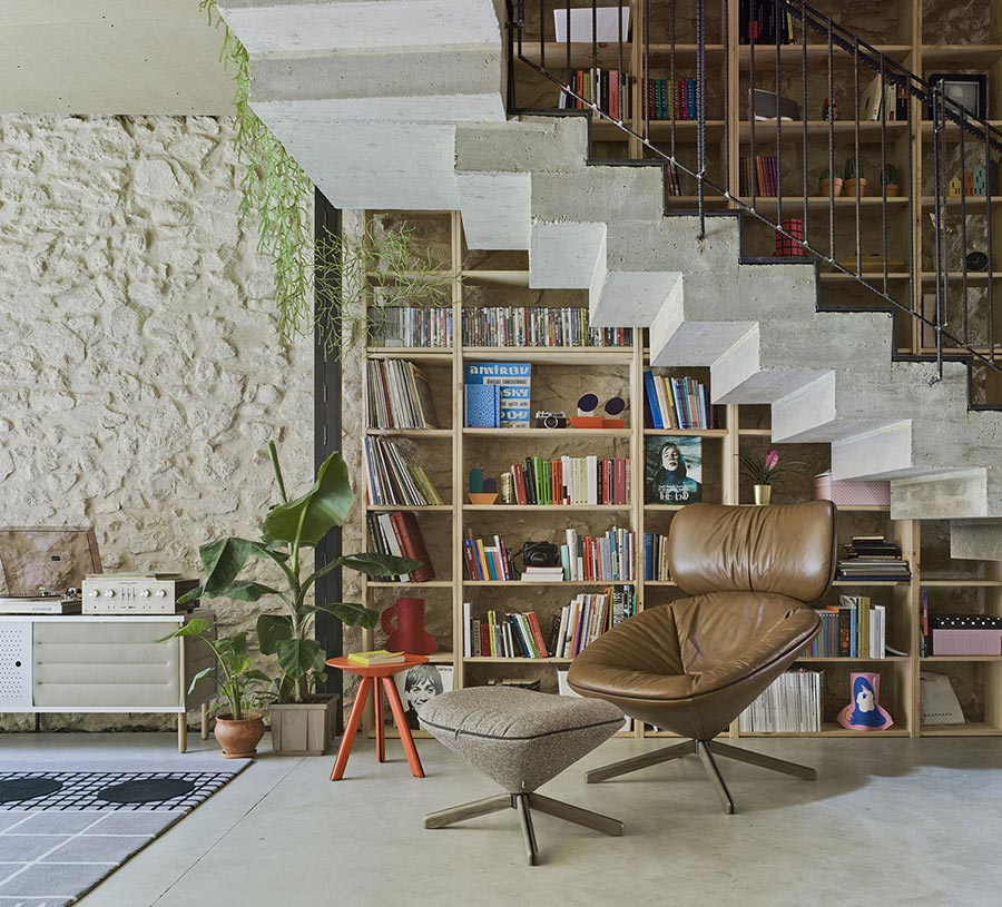 Ambiente de lectura con sillón Tortuga tapizado en piel y reposapiés tapizado en tela