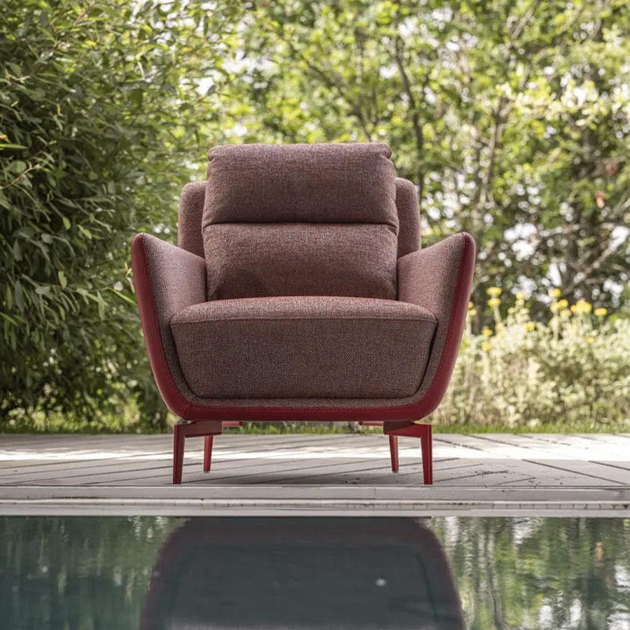 Butaca MK. 1857 de Moorki con patas metálicas, en acabado rojo y vista frontal en ambiente exterior.
