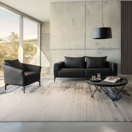 Sofá MK. 1350 de diseño de la firma Moorki en acabado piel master black y vista en ambiente con butaca.