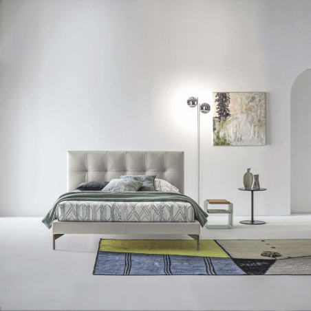 Cama Max Capitonné de la firma de diseño italiano Twils en acabado gris y vista frontal en ambiente.