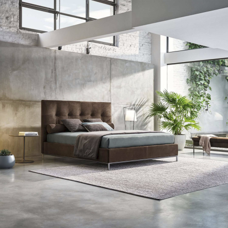 Cama Max Capitonné de la firma de diseño italiano Twils en acabado marrón y vista lateral en ambiente.