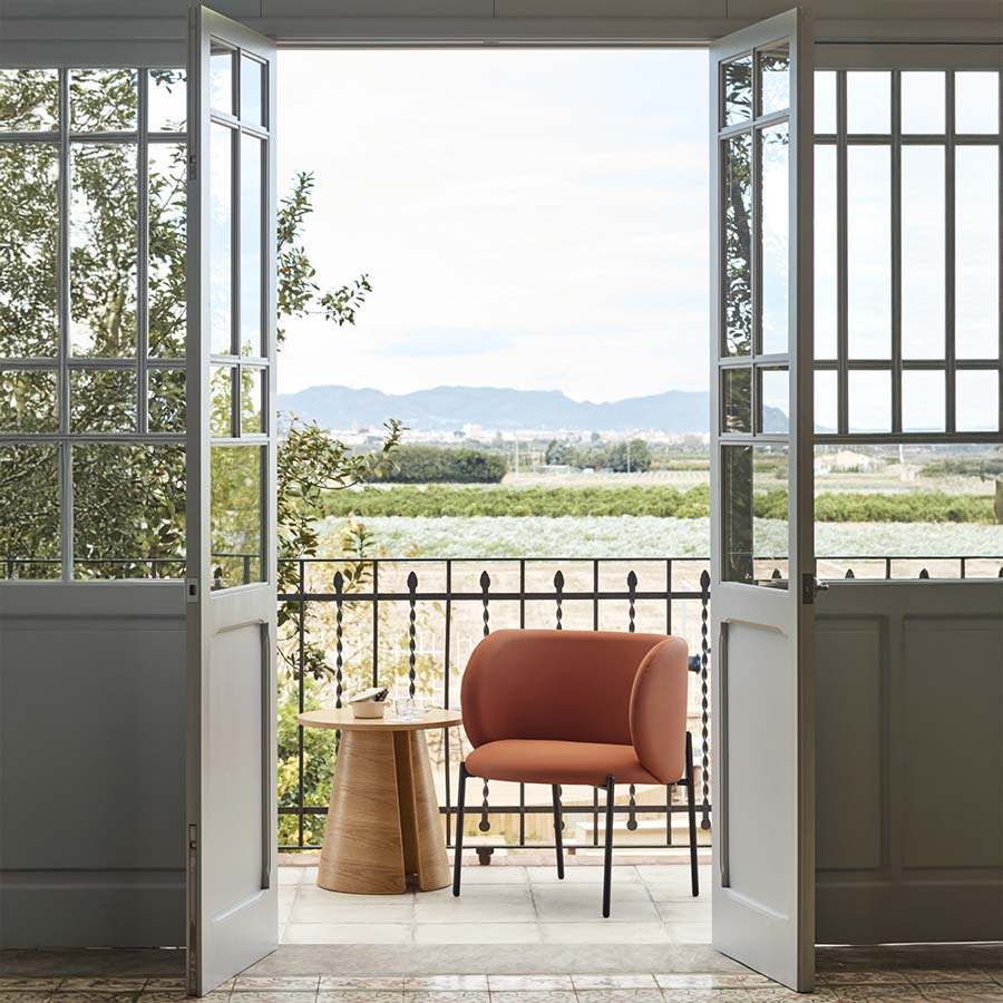 Butaca Mogi de Teulat integrada en ambiente exterior junto a mesa y ventanas