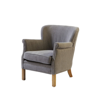 Vista frontal del Sillón en lino gris con tachuelas y patas de madera, de Crisal Decoración 2