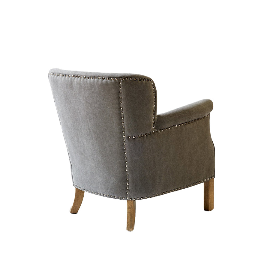 Vista lateral trasera del Sillón de lino gris con tachuelas y con patas de madera de Crisal Decoración
