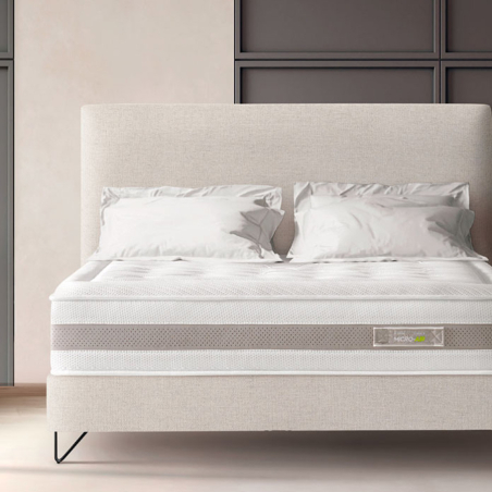 Ambiente de dormitorio con cama tapizada en color beige y colchón Micro Air