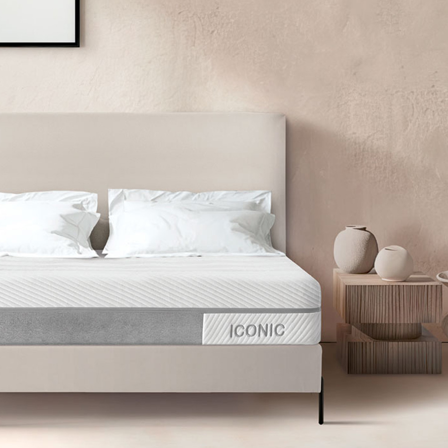 Colchón Iconic en ambiente de dormitorio con cama tapizada en color beige