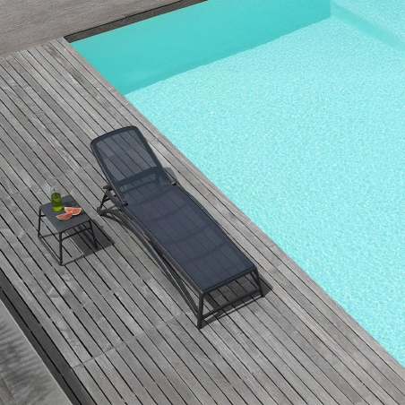 Tumbona atlántico de la firma de diseño italiana Nardi, en acabado antracita y vista de ambiente con mesa pop.