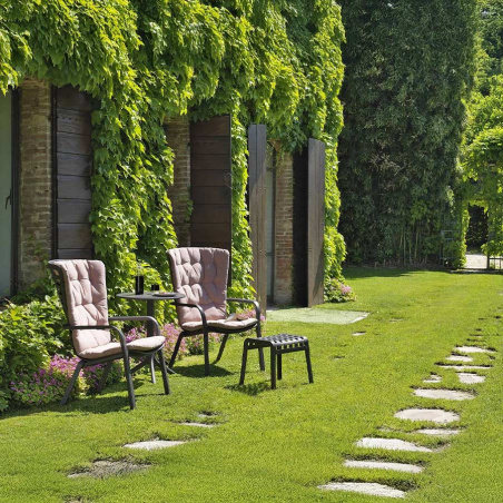 Sillón de terraza Folio confort de Nardi en acabado estructura tortora y cojín rosa, en vista de ambiente de jardín.