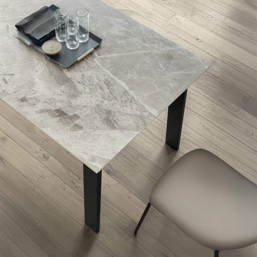 Mesa extensible Deimos de la firma italiana Target Point, en acabado de sobre arabescato y patas negro y vista detalle.