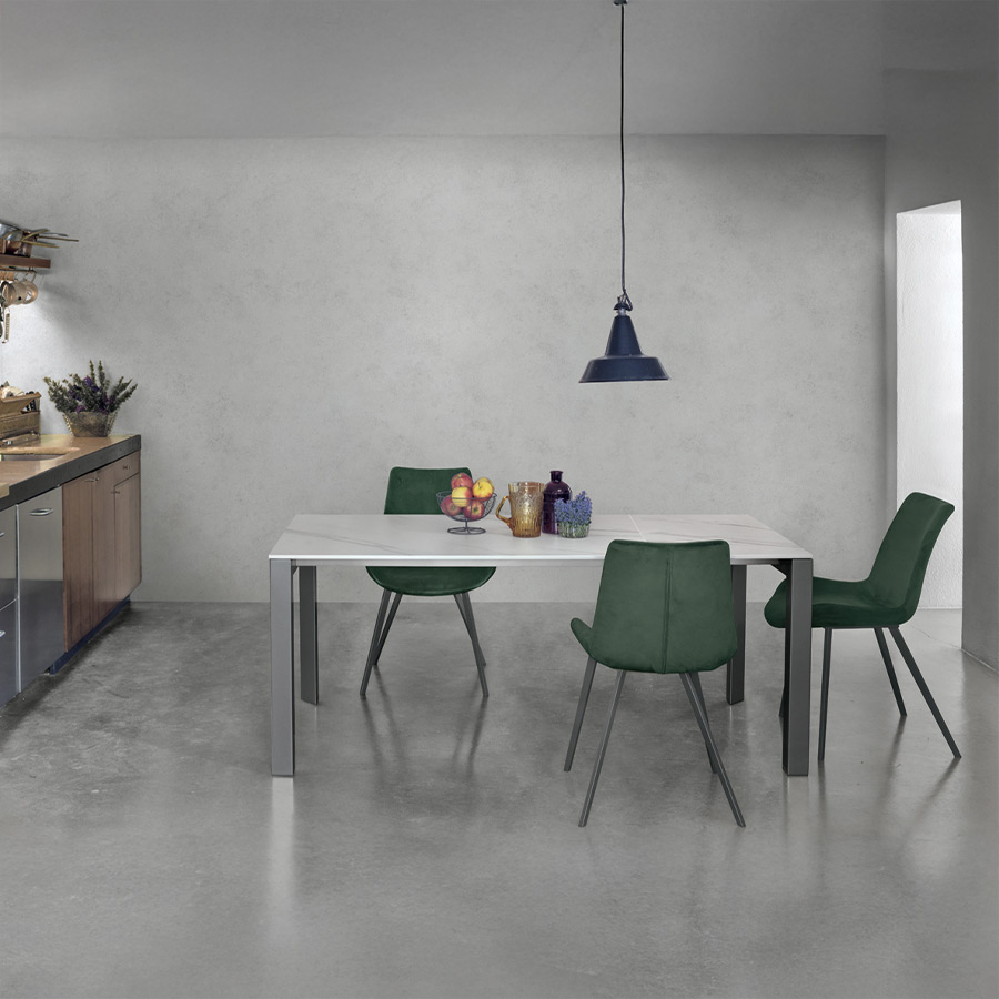 Mesa extensible Enea de Target Point, en acabado del sobre calacatta y estructura grafito y vista de ambiente con sillas Málaga.