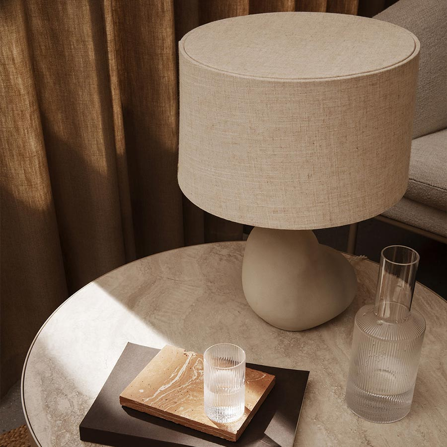 Lámpara Hebe en mesa auxiliar con tulipa natural.
