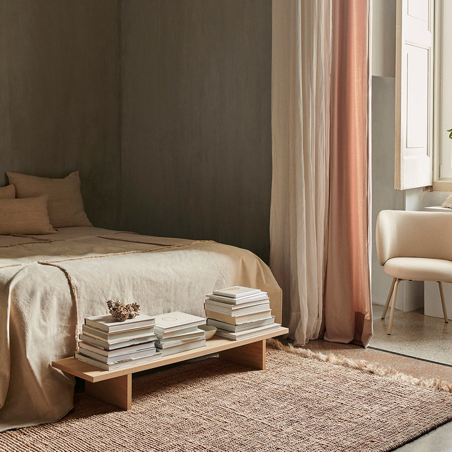 Mesa auxiliar Kona en roble natural en habitación dormitorio.