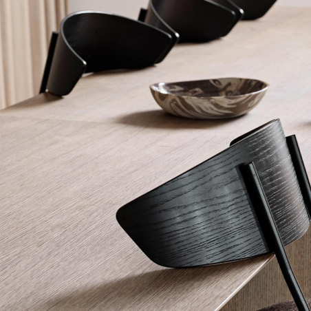 Silla Herman de Ferm Living colgada de respaldo para poder acceder mejor a limpiar bajo la mesa.