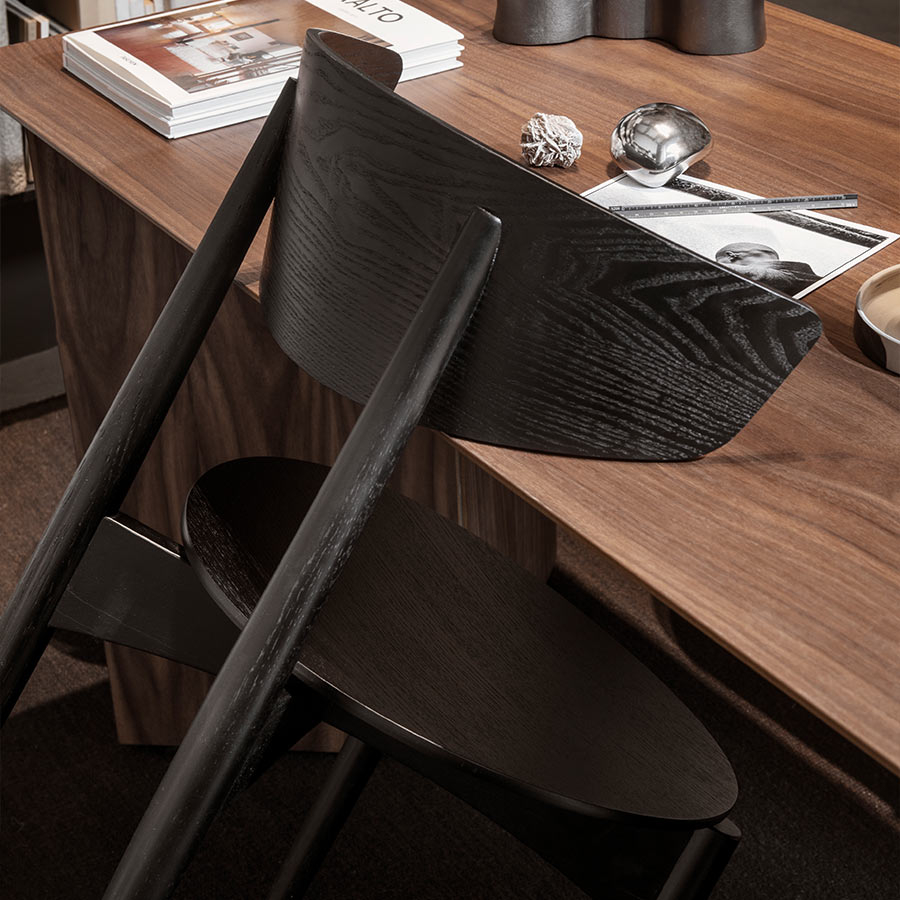Silla Herman de madera apoyada sobre mesa.
