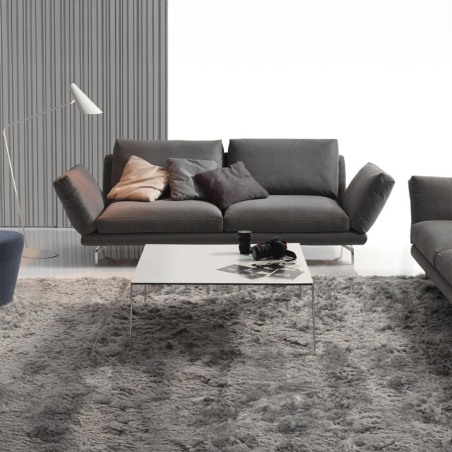 Sofá Axis de Frajumar con hueco entre almohadas, en tapizado gris oscuro y vista de ambiente.