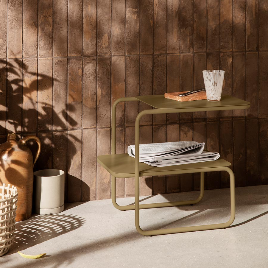 Mesa auxiliar Level verde oliva en ambiente interiro con plantas