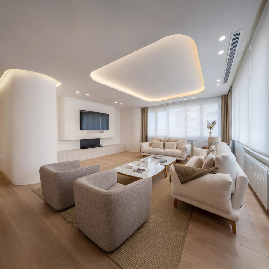 Butaca Ecko de frajumar en tapizado color gris claro y vista de ambiente de salón con sofá Axis.