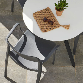 Silla con reposabrazos apilable de color gris oscuro de la firma Resol. 2