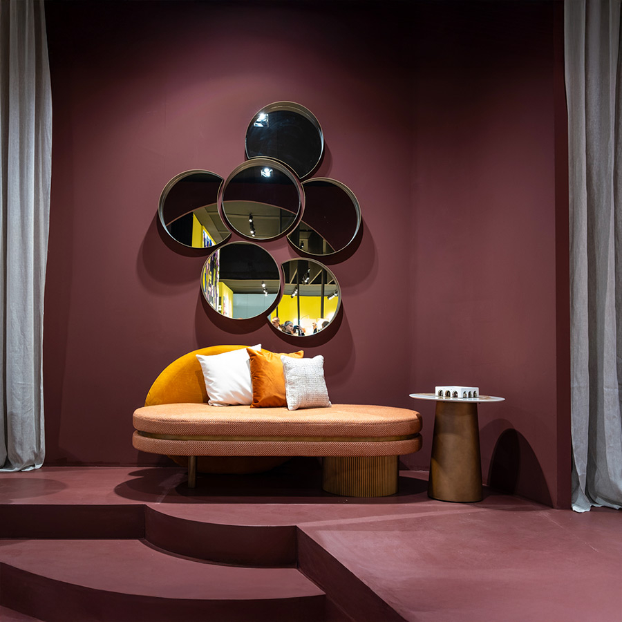 Mesita de centro Tholos en vista de ambiente de exposición  con chaiselongue eclipse