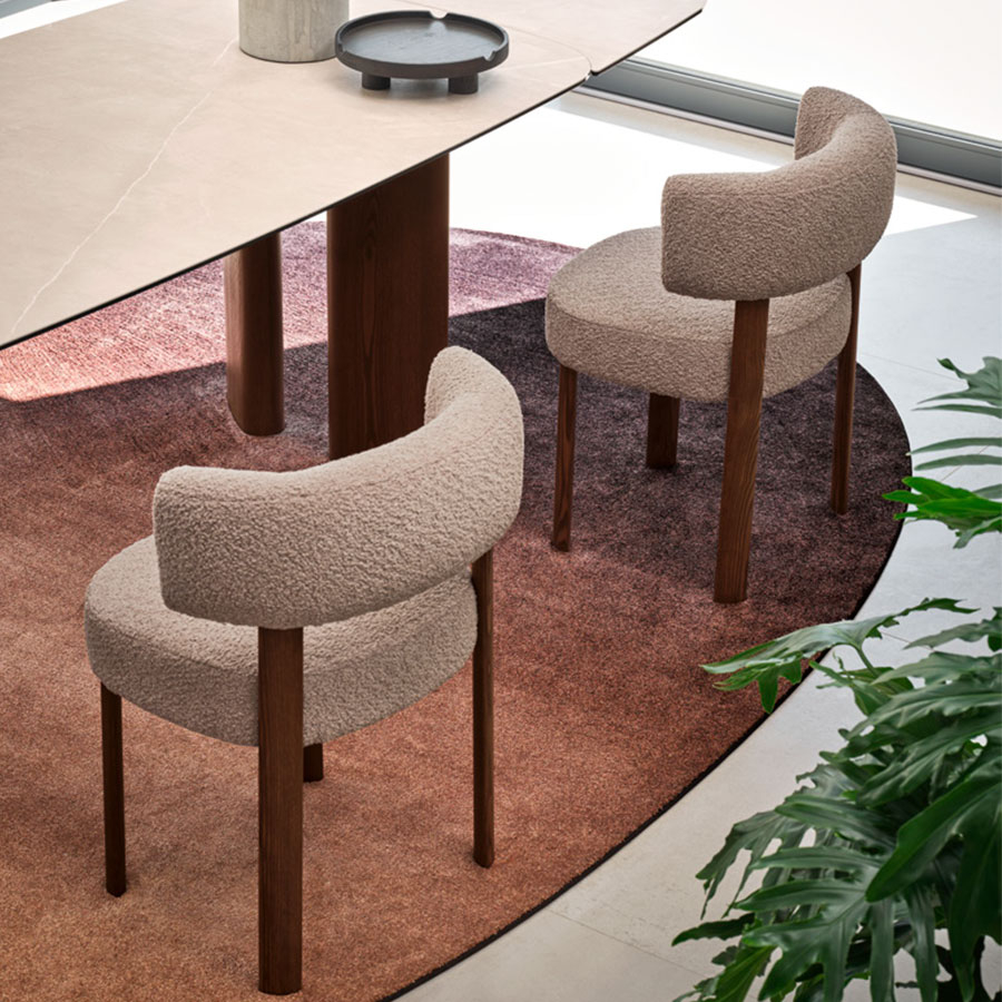 Vista trasera de dos sillas Glen en mesa de comedor, con patas en madera color nogal y asiento beige
