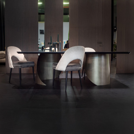 Silla Bonnet en exposición con mesa de comedor Tholo con patas en plata brillante cromada cepillada