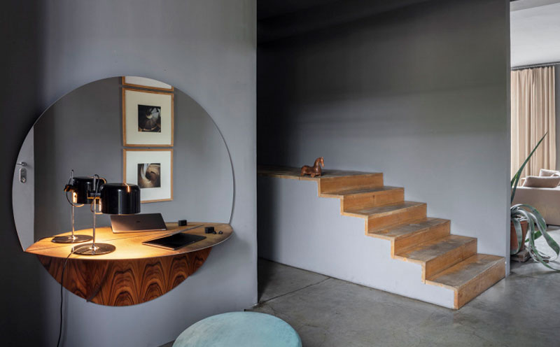 Un salón con una cómoda de madera y un espejo en la pared.