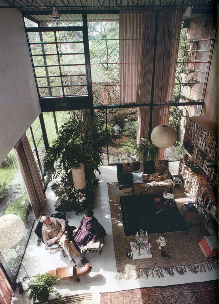 Matrimonio Eames sentados en diseño icónico sillón Eames en su casa