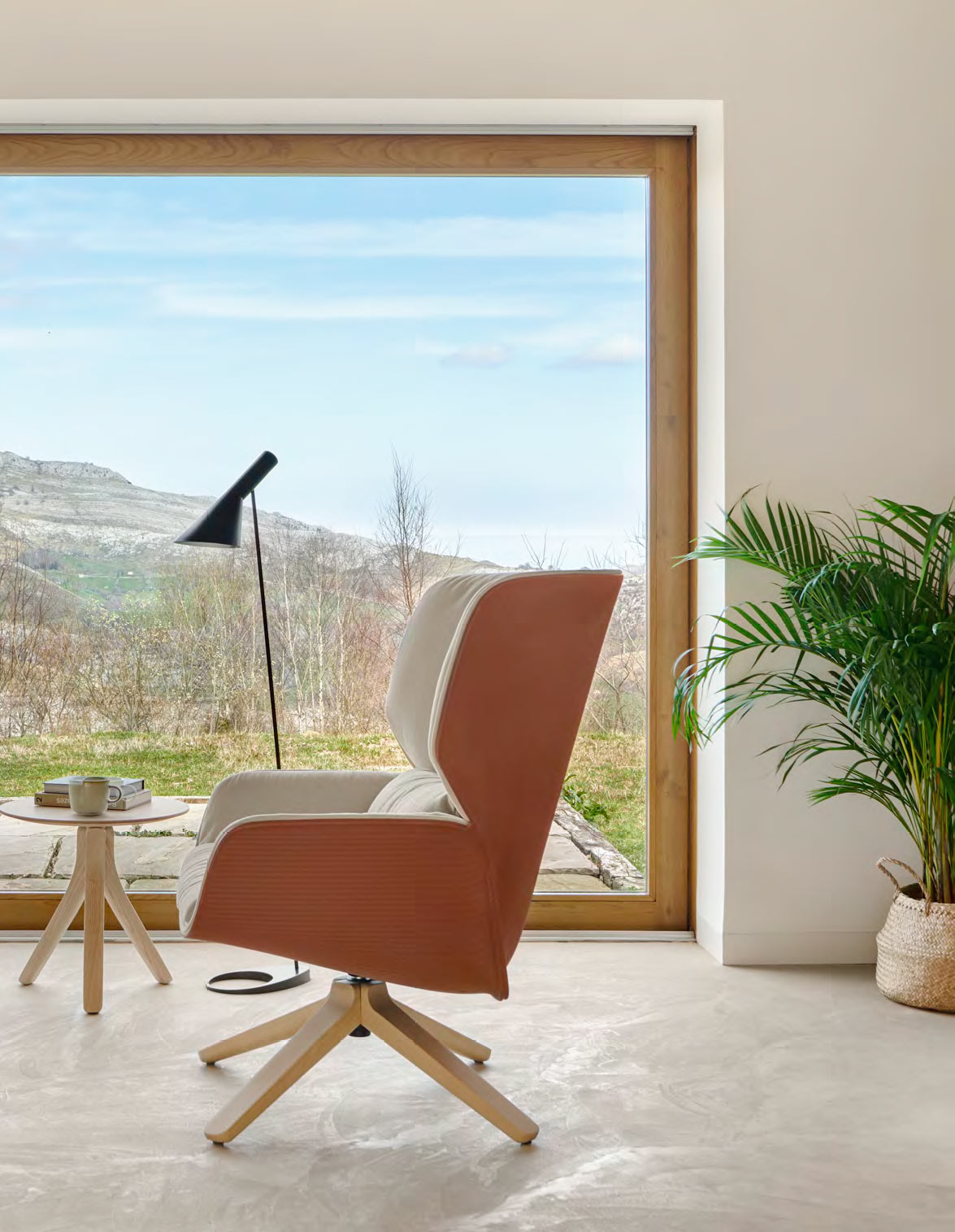 Sillón Nuez Lounge Bio de la marca Andreu World en ambiente de salón con mesita auxiliar y lámpara de pie para leer.