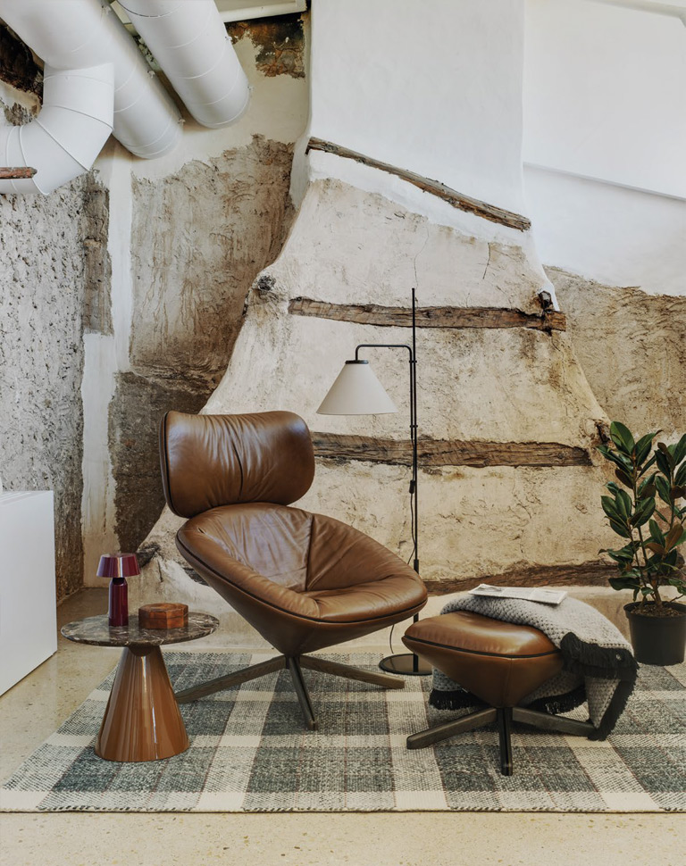 Sillón tortuga en acabado piel, de la marca sancal en rincón de lectura de estilo industrial.