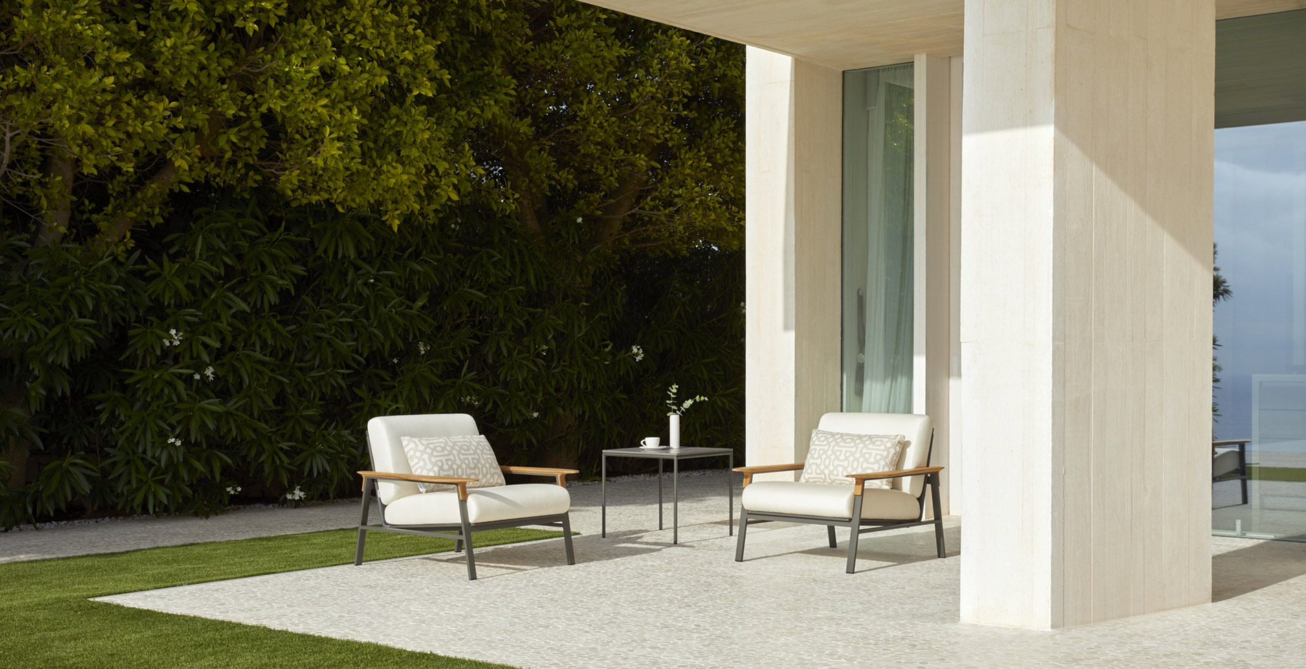 Sillones city de Point con tapizado blanco en terraza de casa de lujo minimalista.