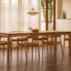 comedor estilo escandinavo cálido con mesa extensible de madera y sillas de madera anchas.