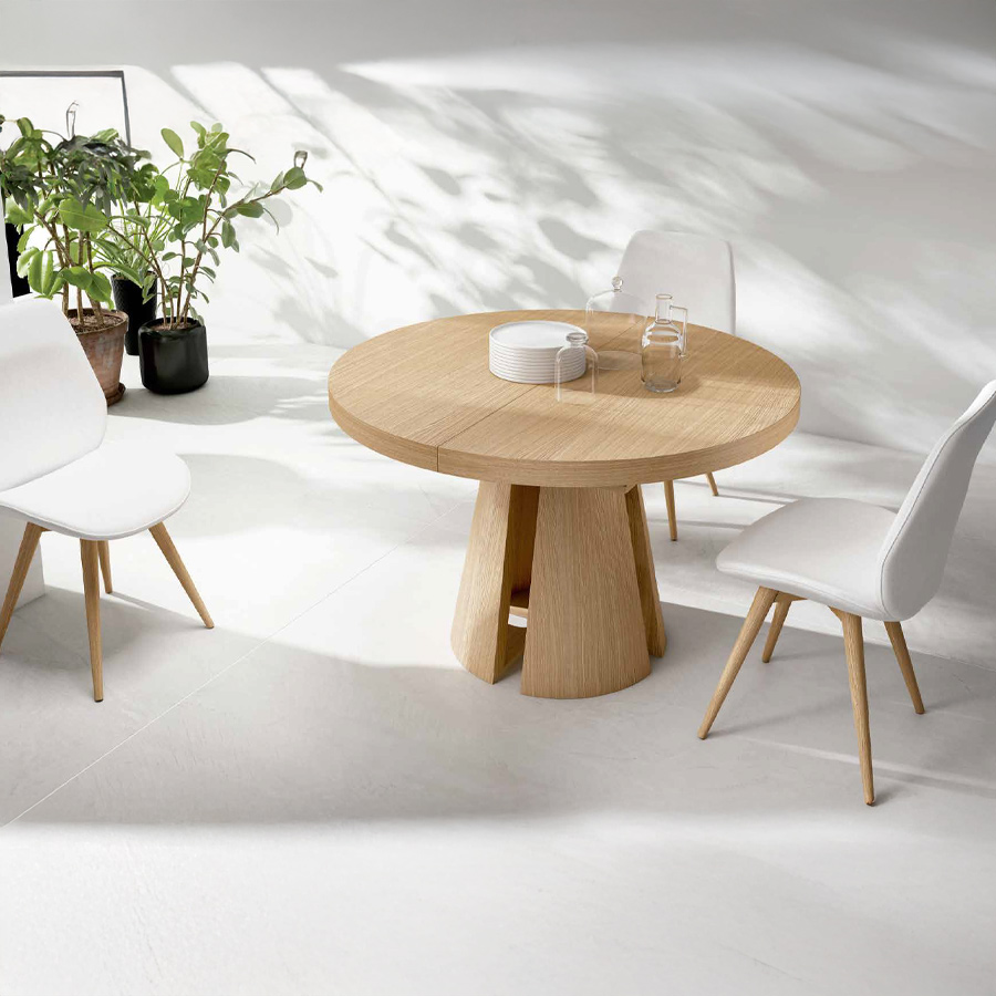 Mesa extensible Bia de Tabula con sobre estructura y sobre en roble y vista de ambiente sillas tapizadas en blanco