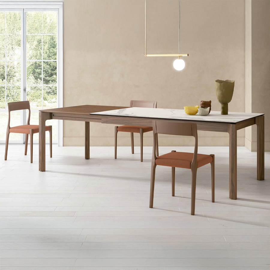 Mesa extensible Mercury de Tabula con sobre en porcelánico y extensible en nogal y vista de ambiente con sillas a conjunto